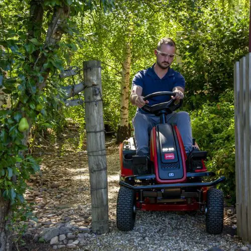 es3000 76cm - man riding mower through gate.