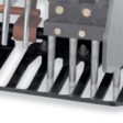 Close-up of a left-hand turf guard with four metal tines and a sturdy black base