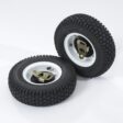 Two black rubber wheels with white rims, designed for a walk-behind mower, showcasing tread and mounting hardware