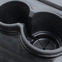 Close-up of the cup holder in the Tara Roadster, featuring a sleek black design and functional grooves