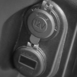 Close-up of the 12V marine outlet and voltmeter on the Tara Roadster's dashboard for easy access