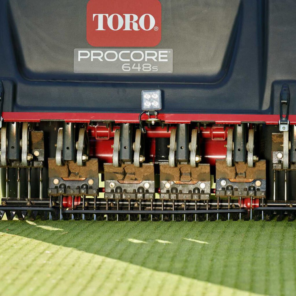 Close-up of the Toro aerator's tines and controls, showcasing its advanced aeration technology and robust design
