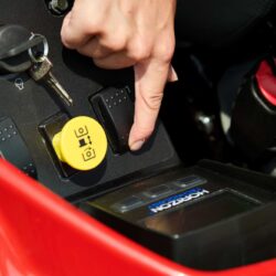Close-up of a hand operating controls on a Toro zero turn mower's dashboard