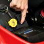 Close-up of a hand operating controls on a Toro zero turn mower's dashboard