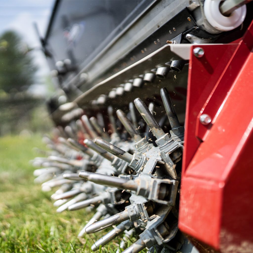 Close-up of the Aera-Vator attachment showing spikes and robust design for aerating turf efficiently