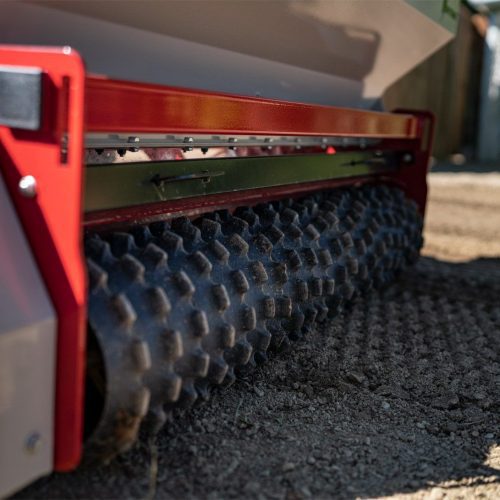 Close-up of the seeder's rubber roller, showcasing its textured surface for soil contact and seed placement