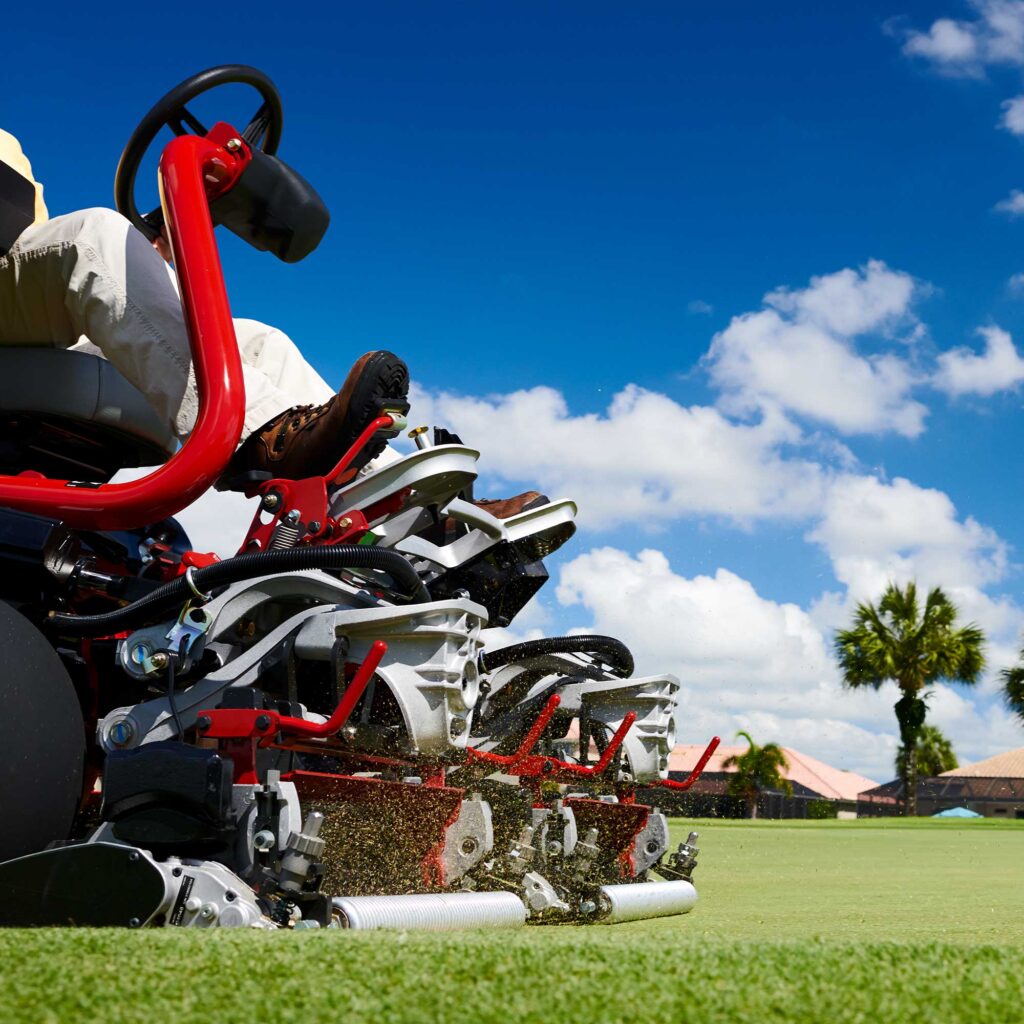 Close-up of the Toro eTriFlex 3360 mower cutting grass, showcasing its electric components and red frame