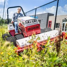 Ventrac Tough Cut Mower Attachment - at commercial or school environment, cutting through overgrown grass and weeds