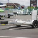 A low-deck trailer with mag wheels and a light ramp for transporting golf carts