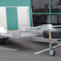 Low-deck trailer for golf carts with a light ramp, mag wheels, and a spare tire