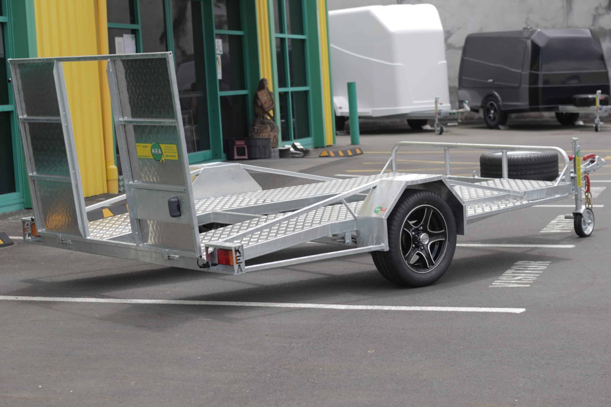 IMG_5866 A low-deck trailer with mag wheels, light ramp, and Duo-Fit coupling for transporting golf carts