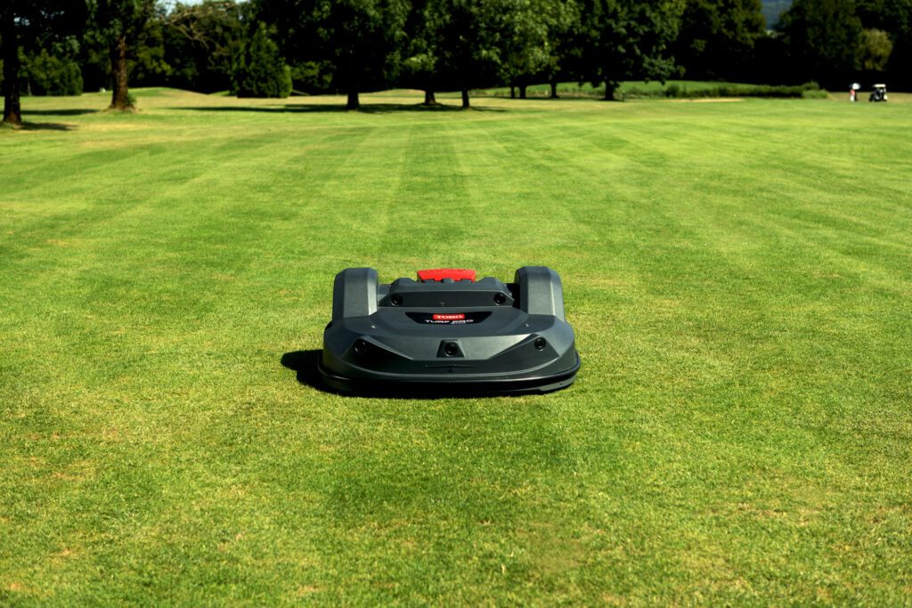 Autonomous mower on a well-manicured lawn, showcasing its sleek design and efficient cutting capabilities.