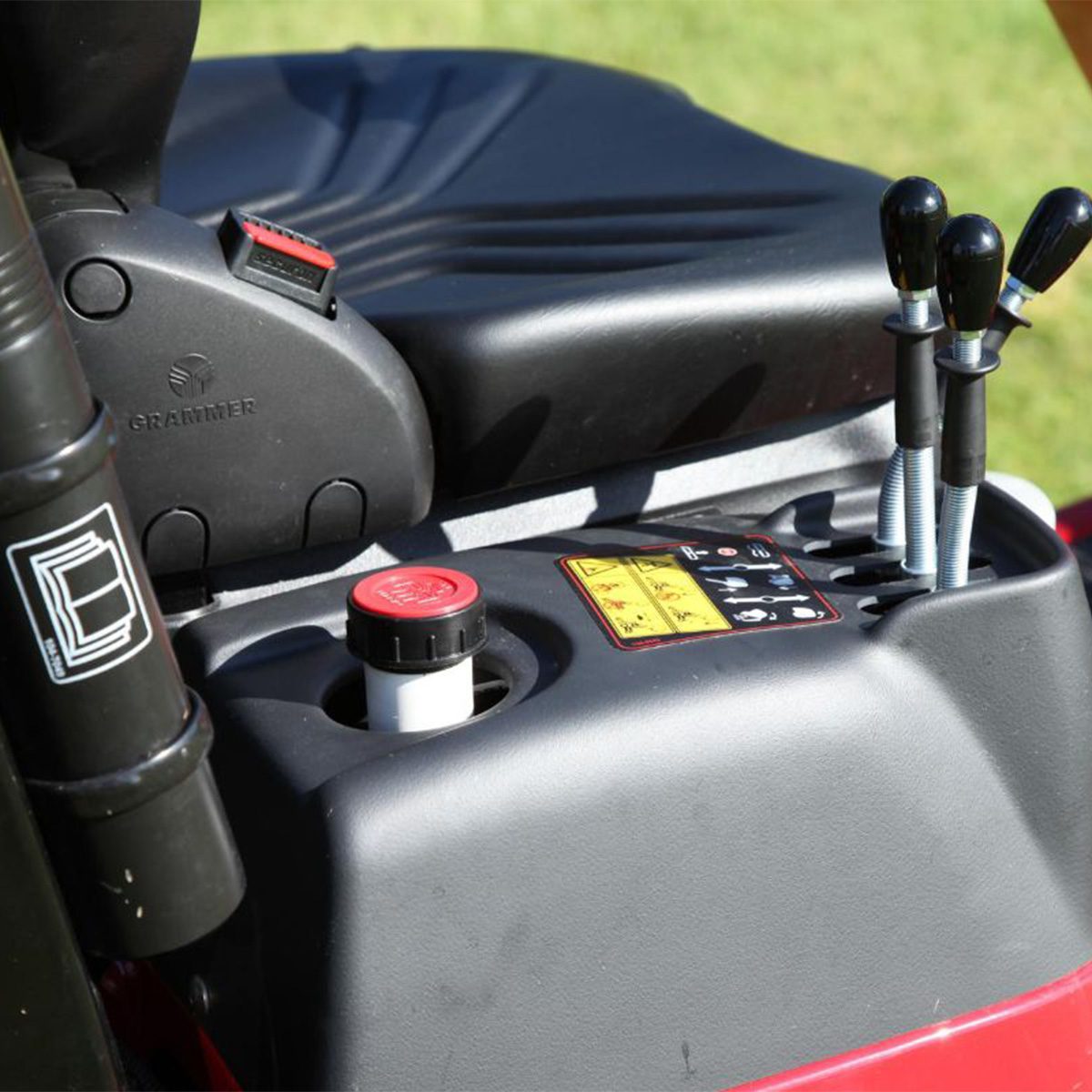 Pro Line H800 31051 Action 3 Close-up of the mower's control panel, featuring levers, a cup holder, and a red fuel cap