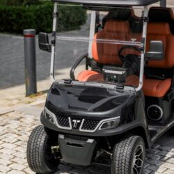 Sleek black golf cart with orange seats, showcasing front view and modern design elements