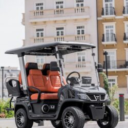 Sleek black golf cart with orange seats, showcasing a modern design and spacious seating for four