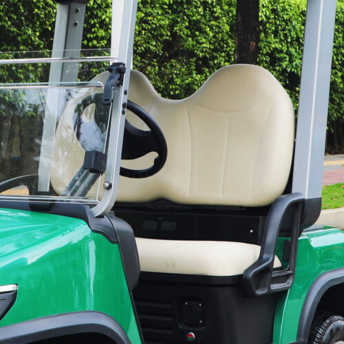 A close-up of a green golf cart's interior, featuring a beige seat and steering wheel