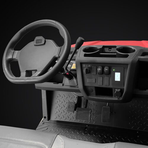 Interior view of a red utility vehicle showcasing the steering wheel, controls, and dashboard features