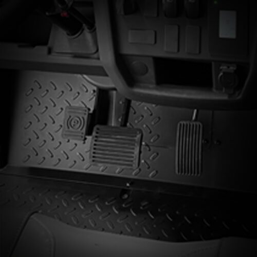 Close-up of the pedal area in a utility vehicle, showcasing textured flooring and control pedals