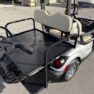 Rear view of a 2015 Yamaha PTV golf cart in Moonstone Silver with beige seats and a flatbed