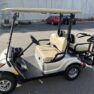 Silver 2015 Yamaha golf cart with beige seats, parked on a paved surface, showing light use