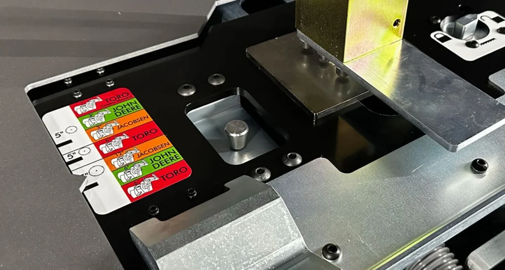 Close-up of a grinder's control panel showing labels for different mower brands and adjustment settings