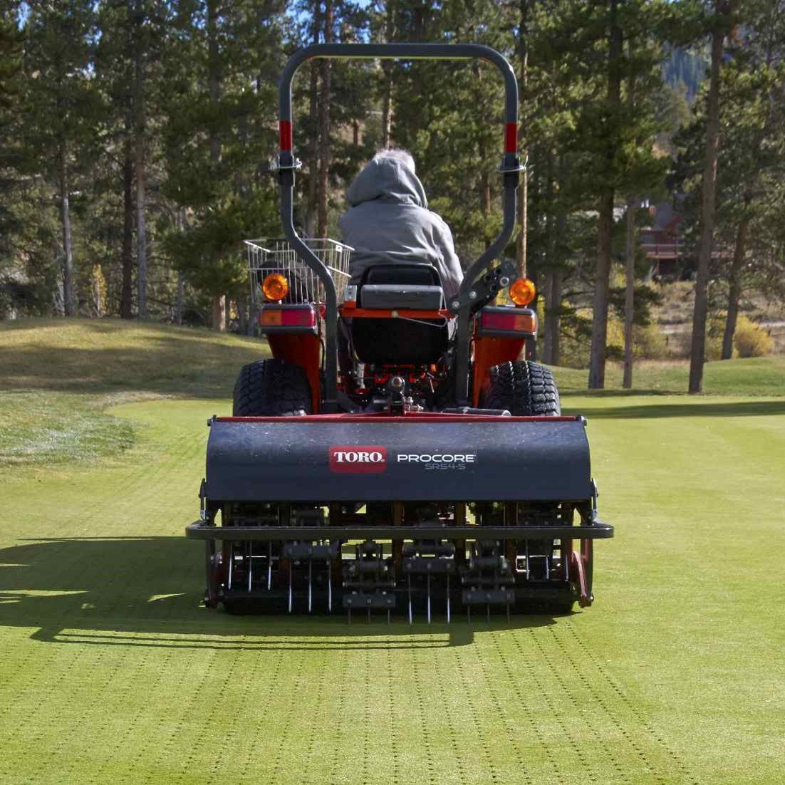 cm14_3119s_procore_sr54-s_colorado_6-square-2 A person operates a Toro aerator on a green lawn, showcasing its deep-tine aeration capabilities