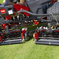 Close-up of Toro mower's cutting units showcasing precision adjustment and robust design on green turf