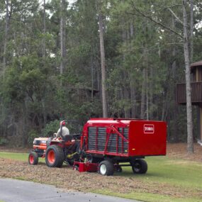 Sweeper clearing debris off golf course