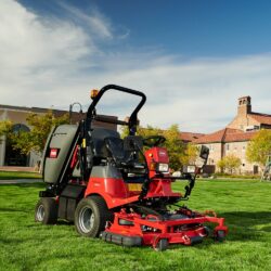 Red Toro ride-on mower on green grass, showcasing its out-front deck and high-lift collection system