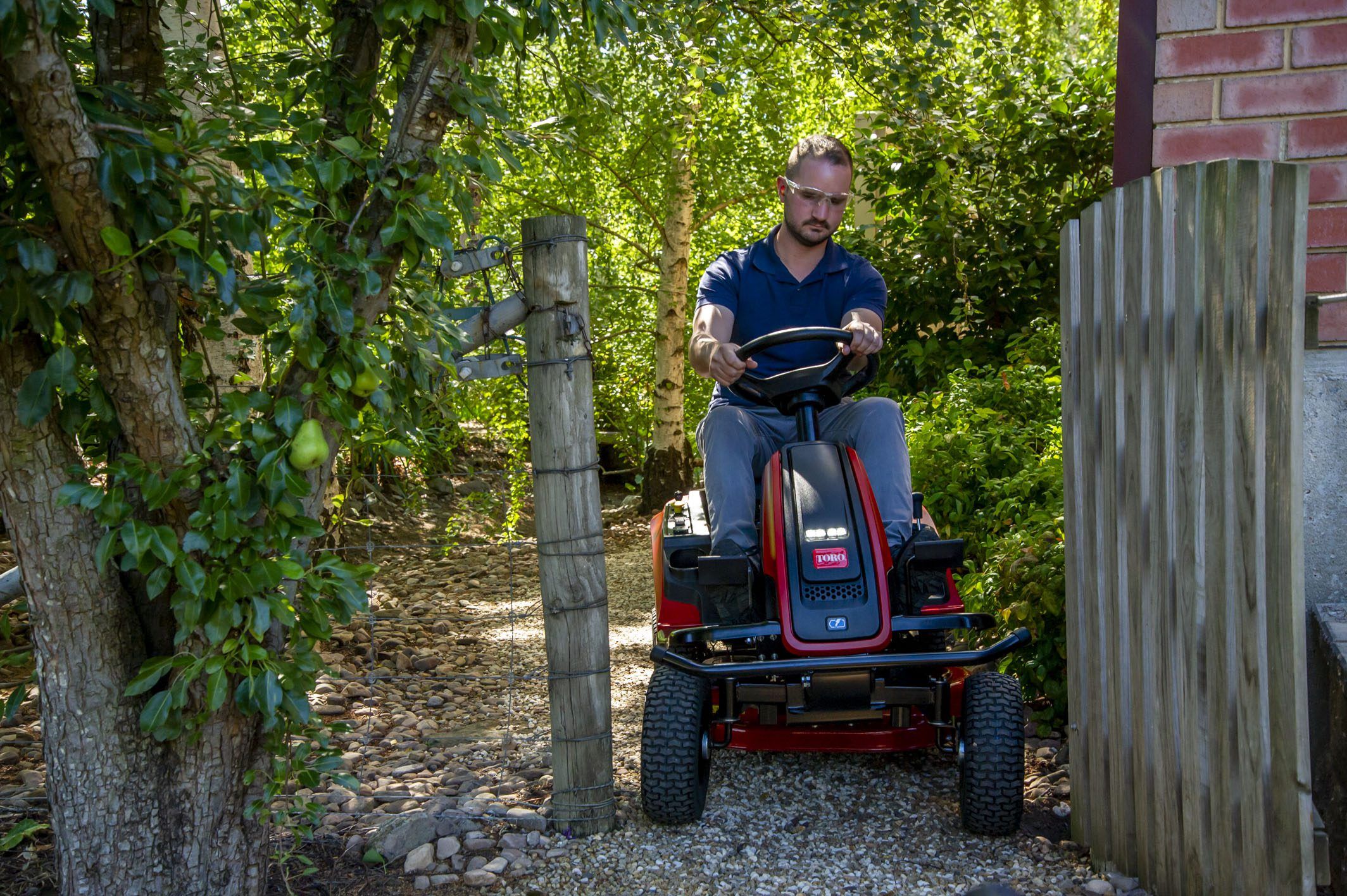 es3000 76cm - man riding mower through gate.