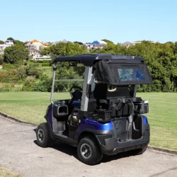 Sleek electric golf cart with a stylish design parked on a golf course path, showcasing its ergonomic features