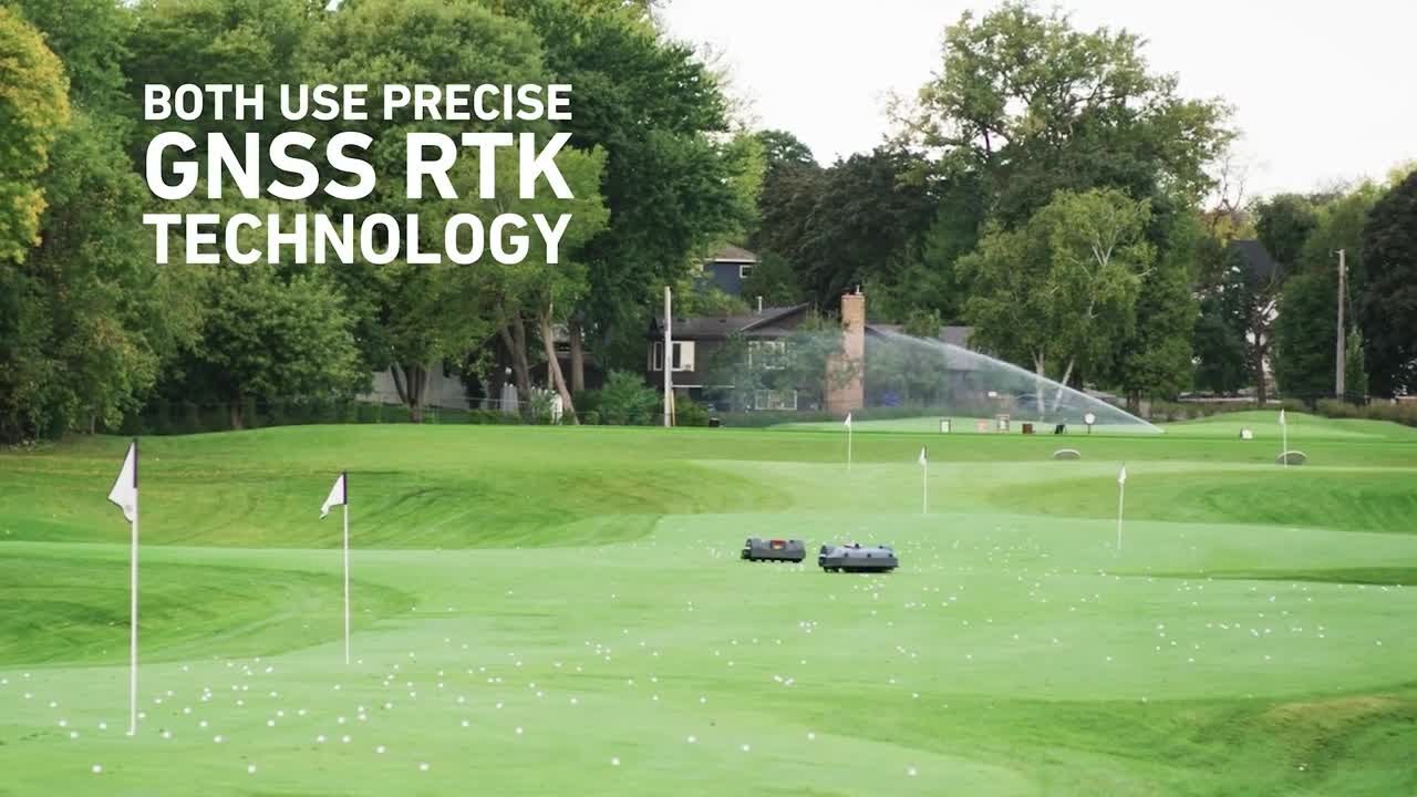 Two autonomous mowers operate on a golf range, surrounded by flags and scattered golf balls