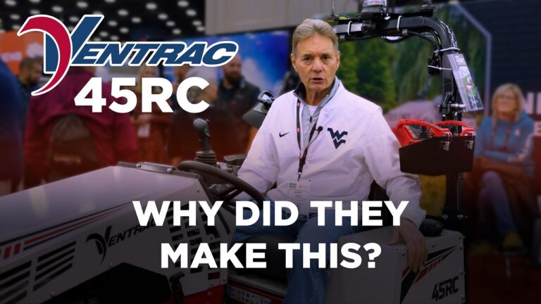 A man sits on a Ventrac 45RC, discussing its features at an event